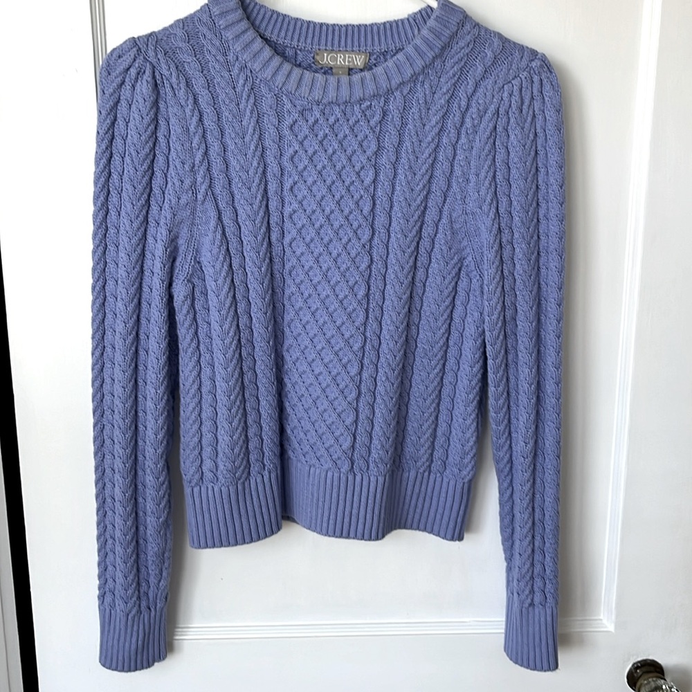 Cable knit crew neck sweater.